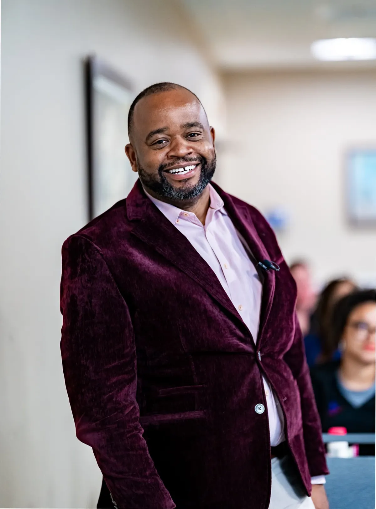 Portrait of Dr. Obinna Nwobi in a burgundy suit jacket, smiling.