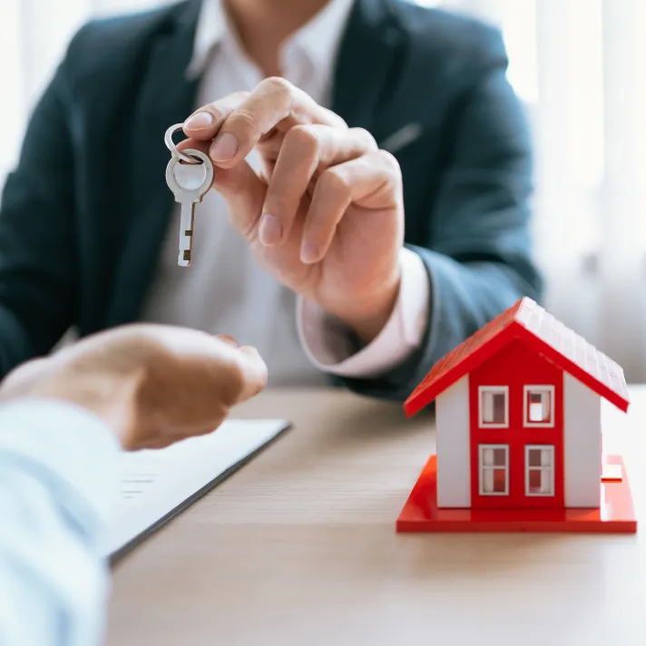 A man offering a key in a real estate transaction.