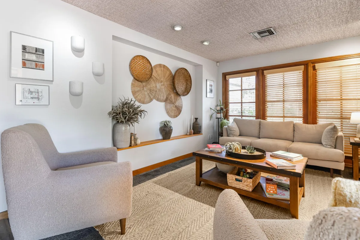light walls, comfortable seating, subtle natural decor, and baskets arranged on the wall evoke a calm