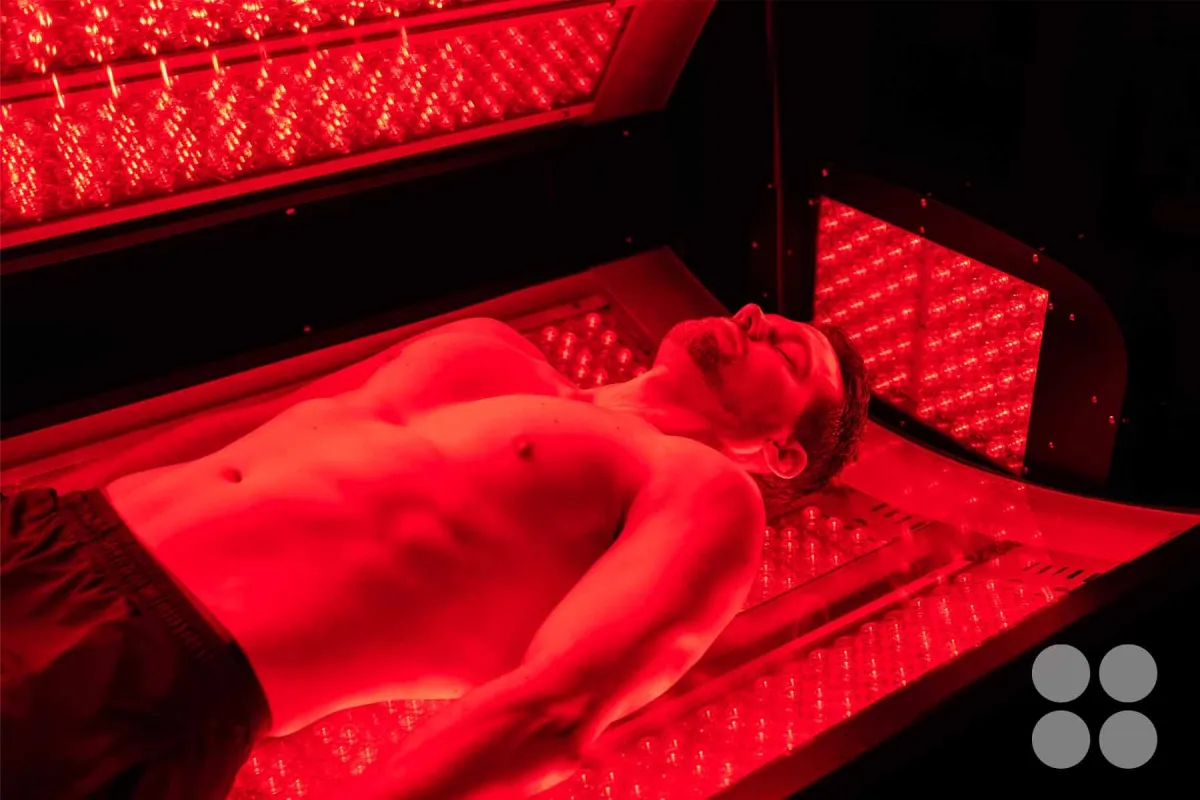 man in red light bed