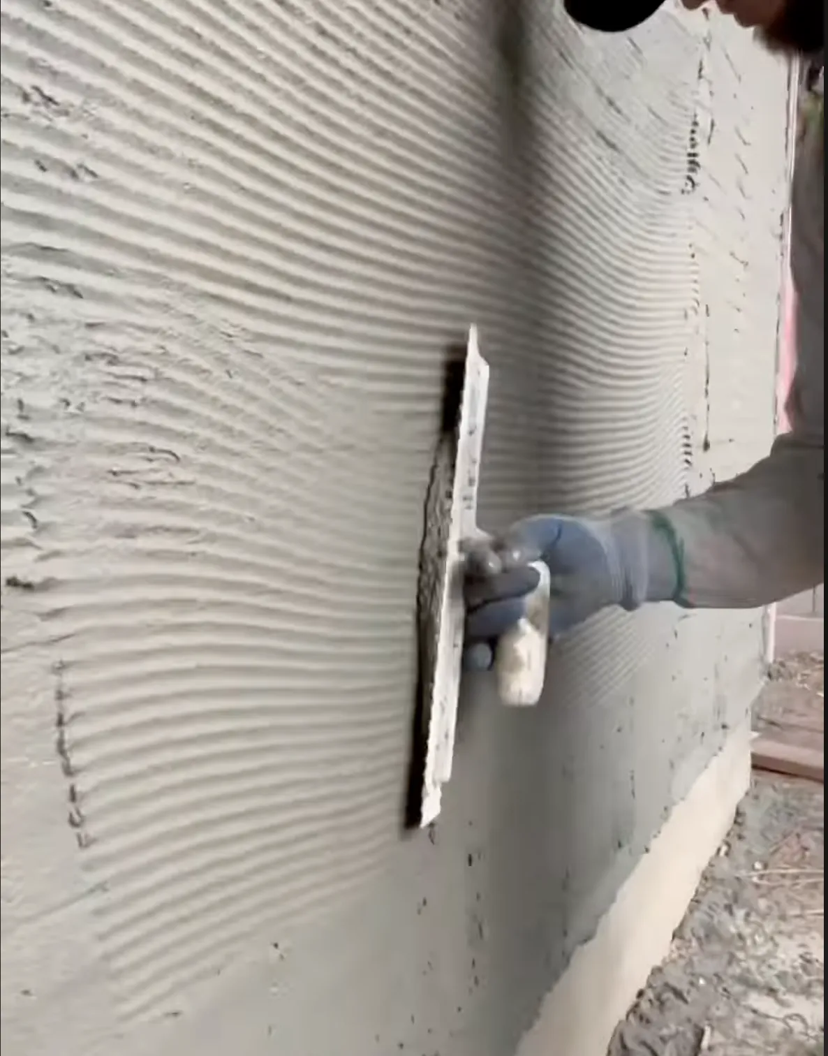 man applying smooth stucco to a wall