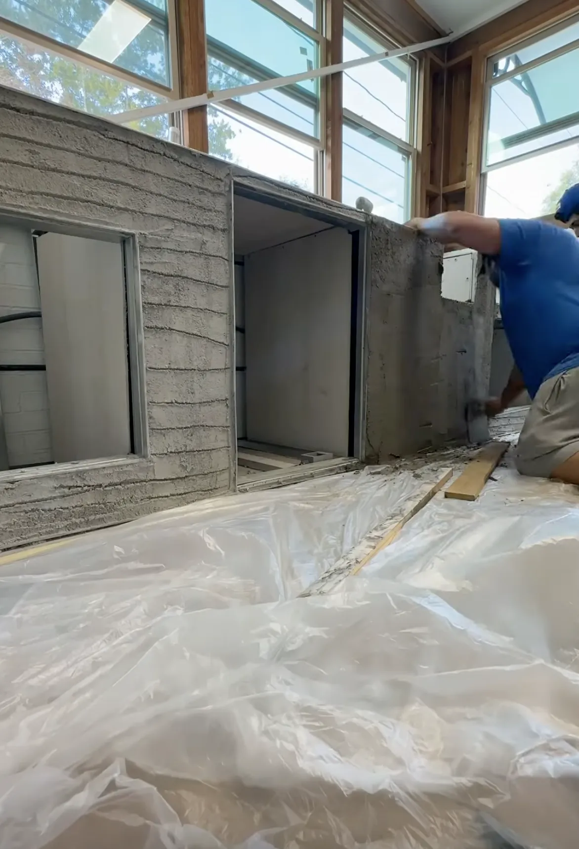 man with blue shirt applying new indoor stucco