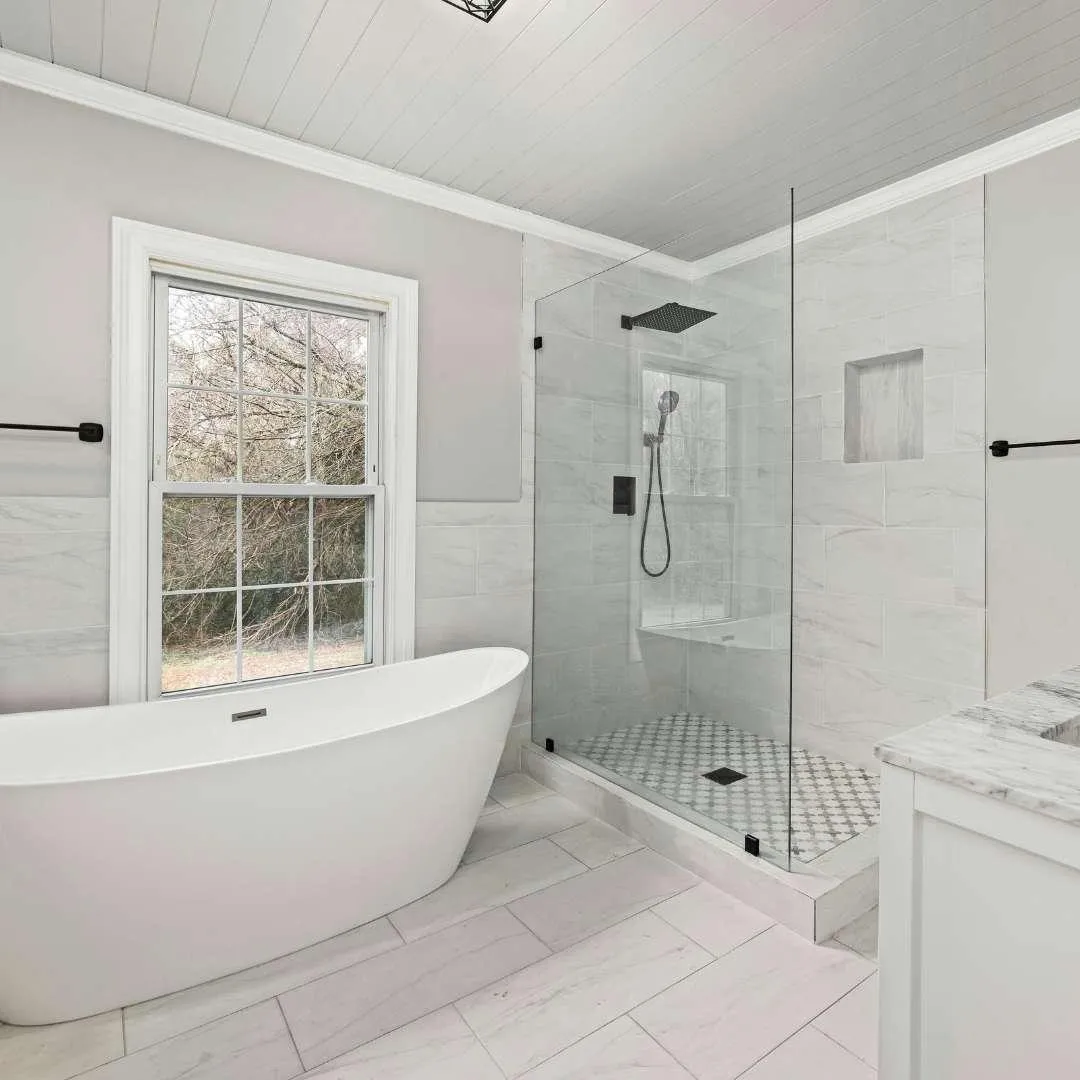 Sleek master bathroom remodel with double sinks and glass shower enclosure