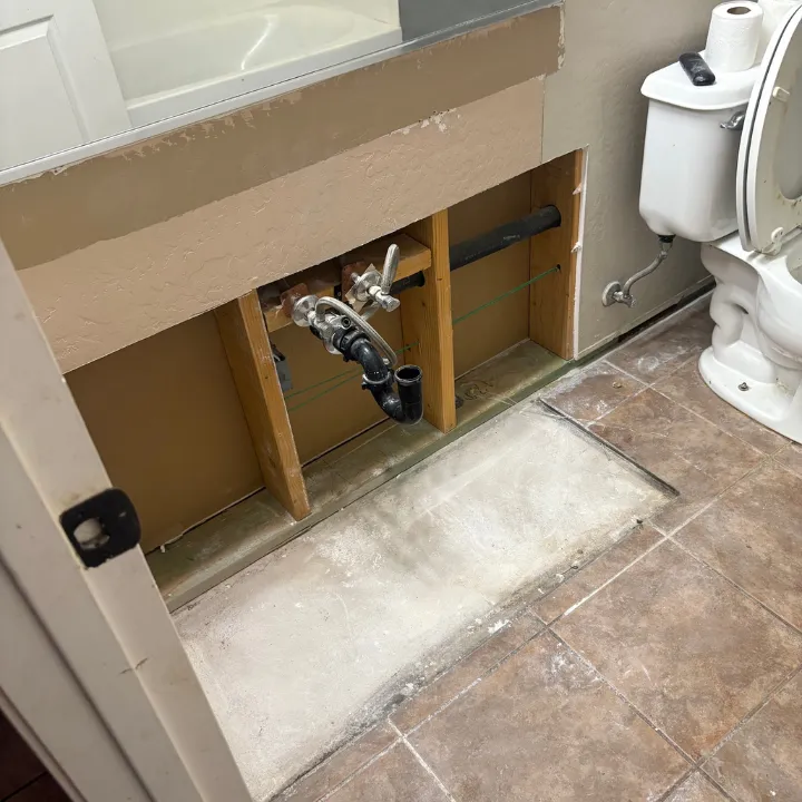 Flood cut drywall removal exposing framing and plumbing in a Phoenix bathroom