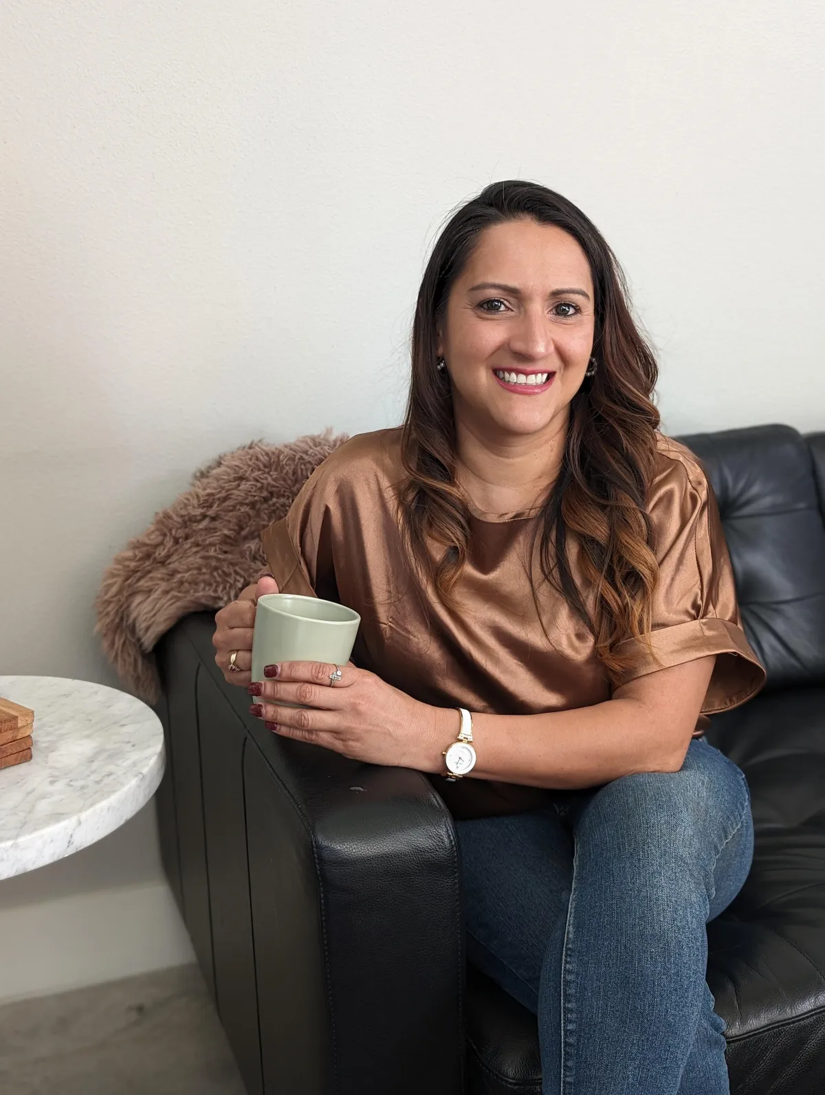 photo of denise sitting with a cup of coffee