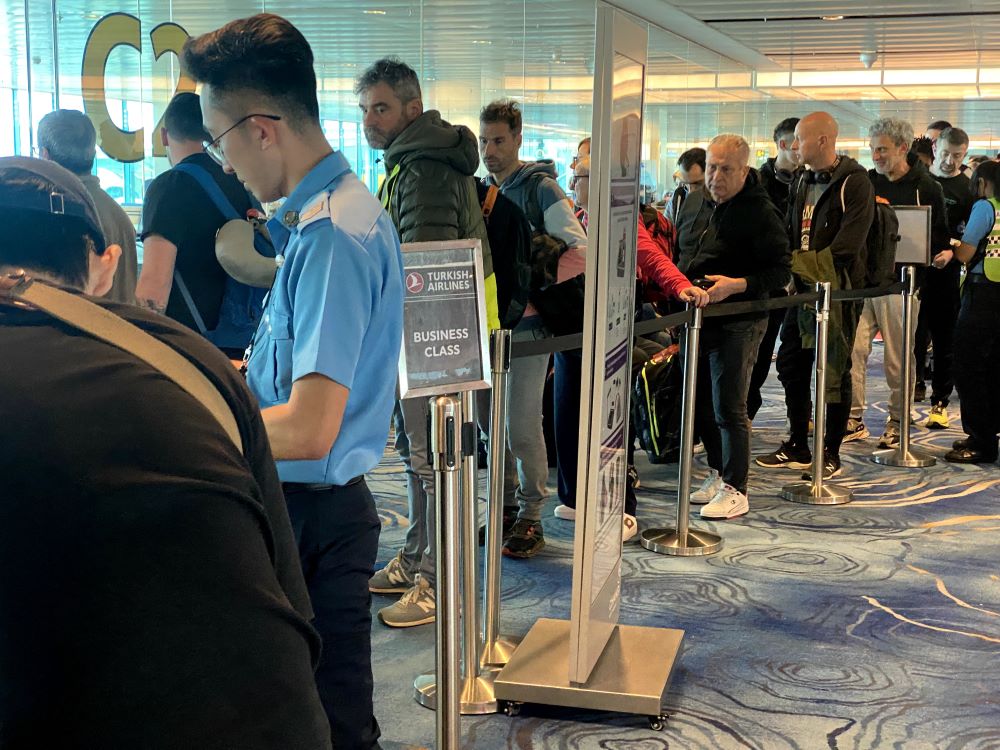 Busy airport check-in queue at Turkish Airlines business class counter