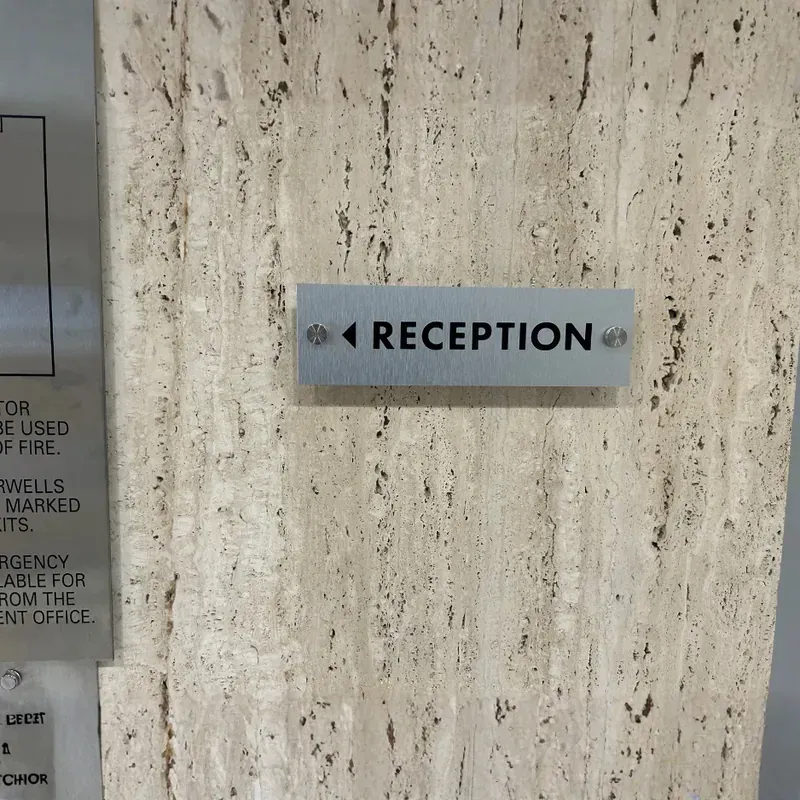 Modern dimensional acrylic lobby sign mounted on a textured wall for a corporate reception area