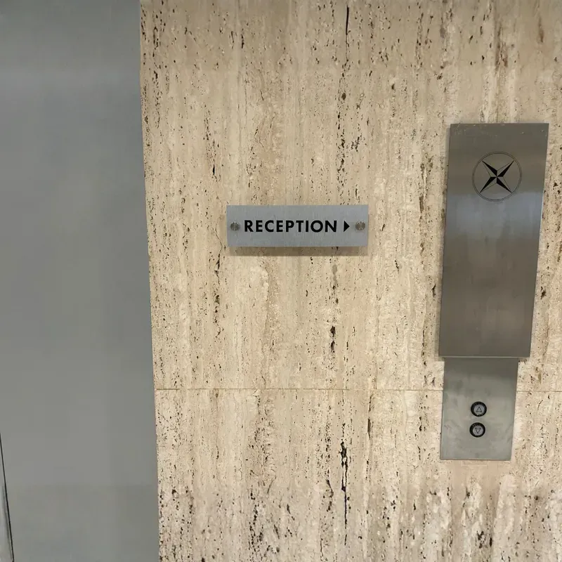 Modern dimensional acrylic lobby sign mounted on a textured wall for a corporate reception area