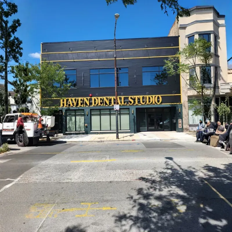 High-visibility dark brick storefront for Haven Dental Studio featuring illuminated gold channel letter signage