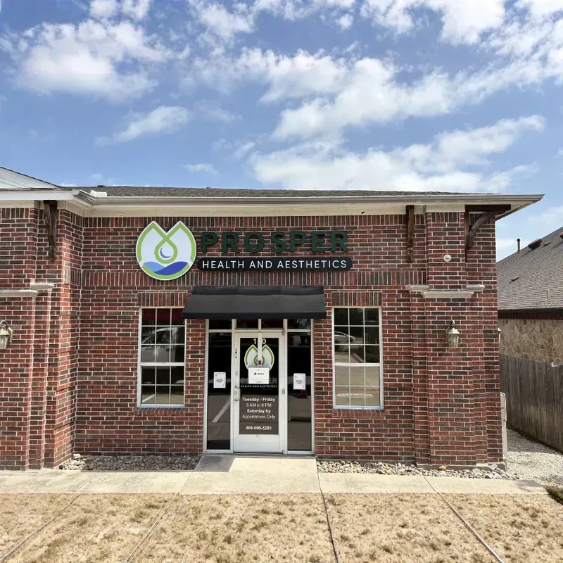 Exterior of a professional red brick commercial building featuring custom window graphics and building identification signage