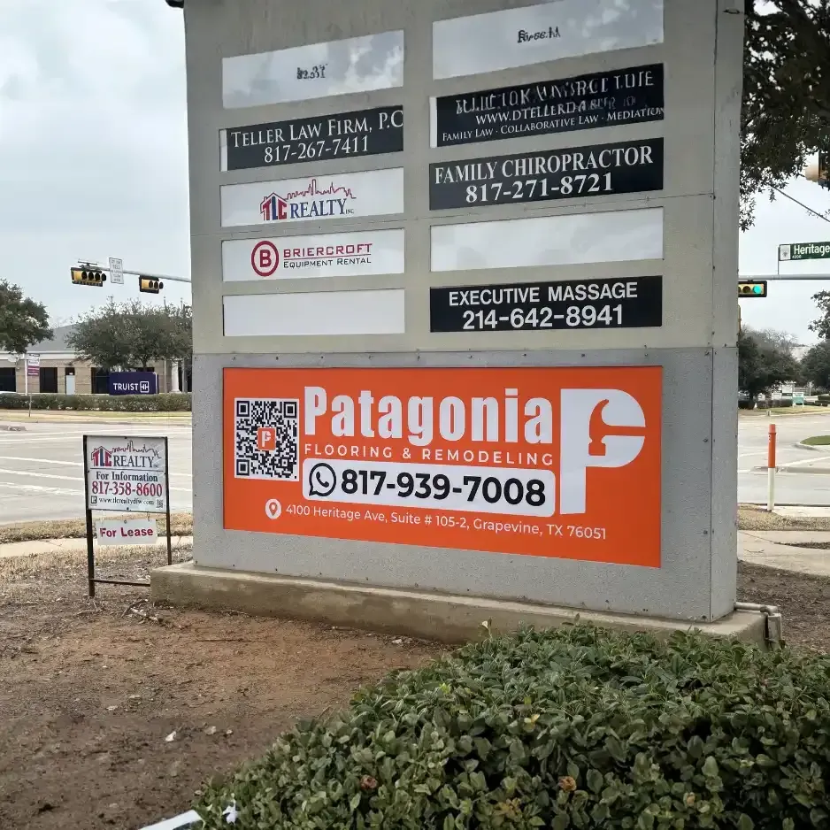 Multi-tenant monument sign for a commercial plaza featuring professional panels for businesses like Patagonia and a family chiropractor