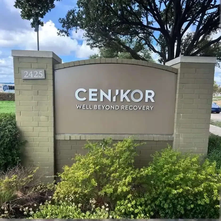 Large stone monument sign for Cenikor featuring clean, modern dimensional lettering and green landscaping