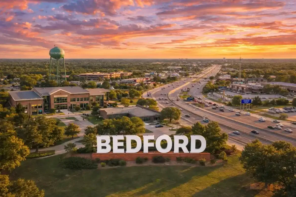 Panoramic sunset view over the city of Bedford, Texas, showing local roadways and suburban landscapes