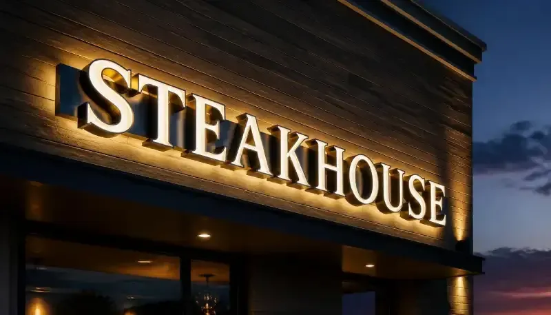 Illuminated dimensional channel letters with front lighting and a soft halo glow mounted over a concealed wireway.