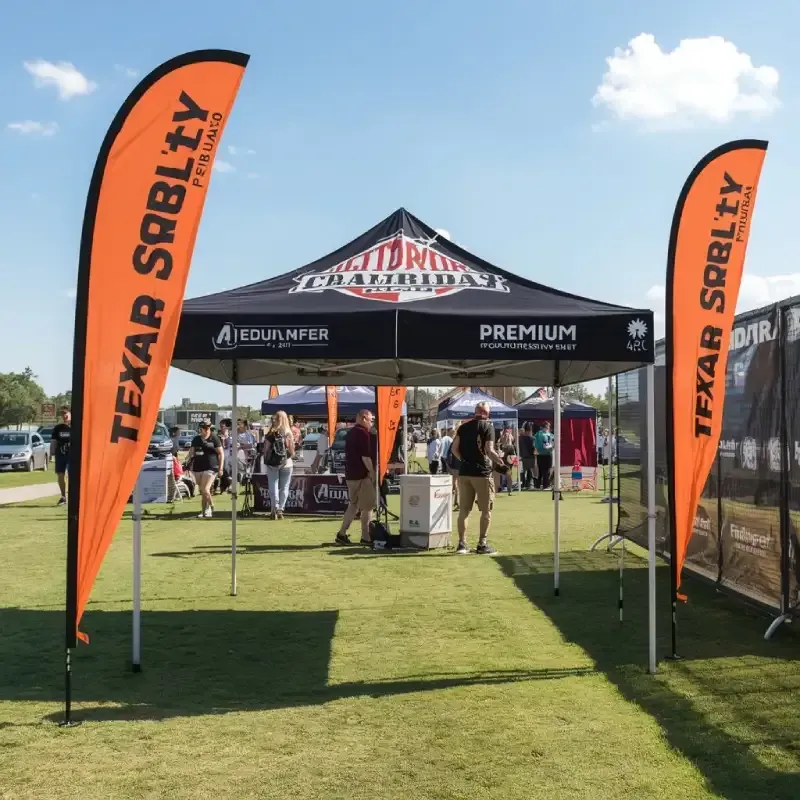 Branded outdoor event canopy tent with feather flags and weighted legs at a community festival.