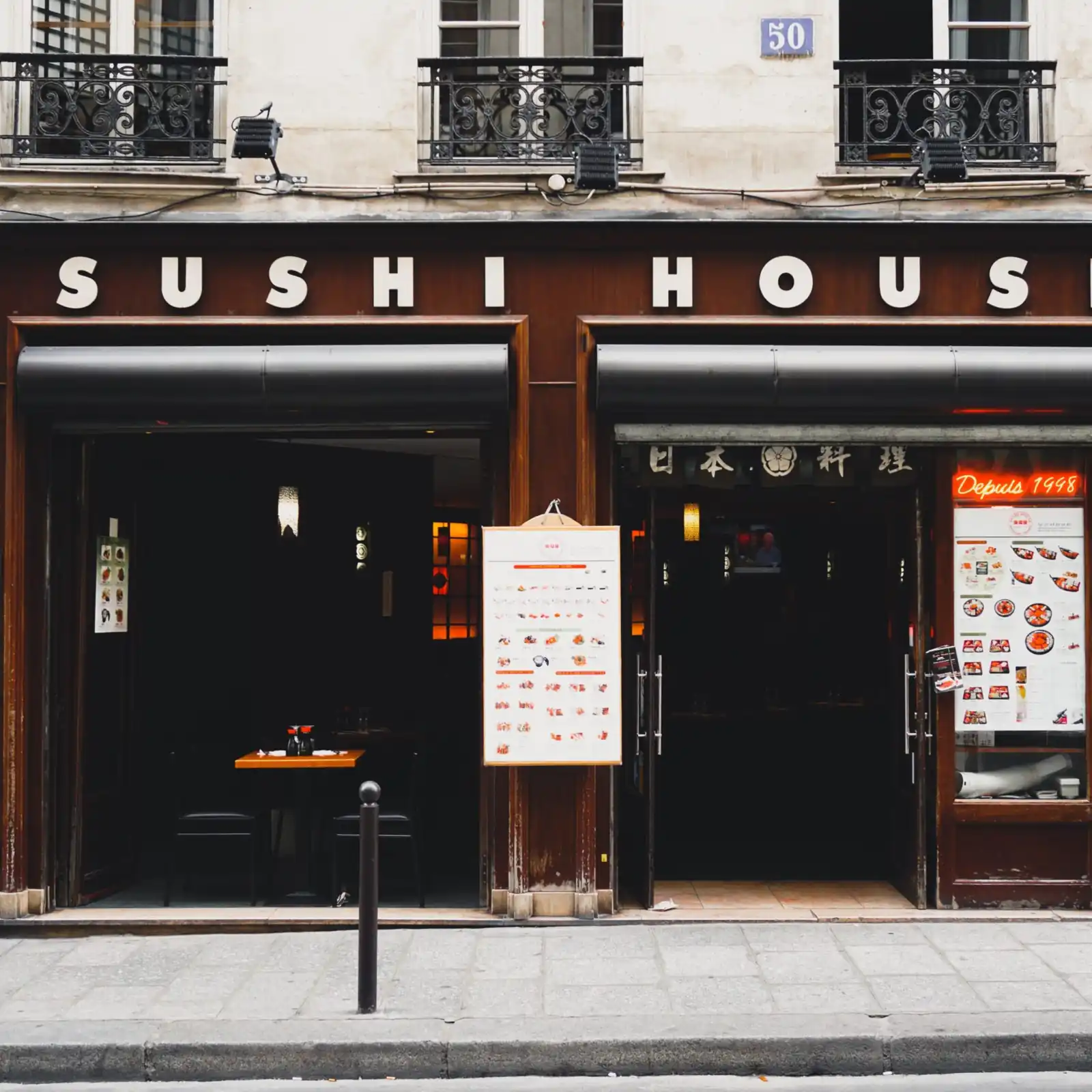 Illuminated exterior storefront sign and menu board for Sushi House restaurant.