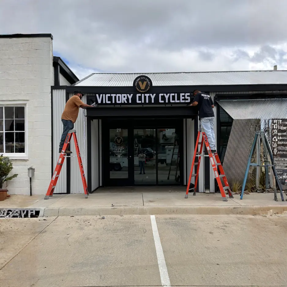 Professional installation of black channel letter signage for Victory City Cycles above a storefront in Fort Worth