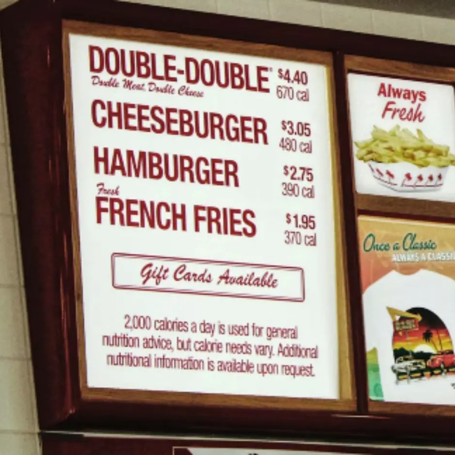High-visibility indoor menu board display for a fast-casual restaurant showing pricing and nutrition.