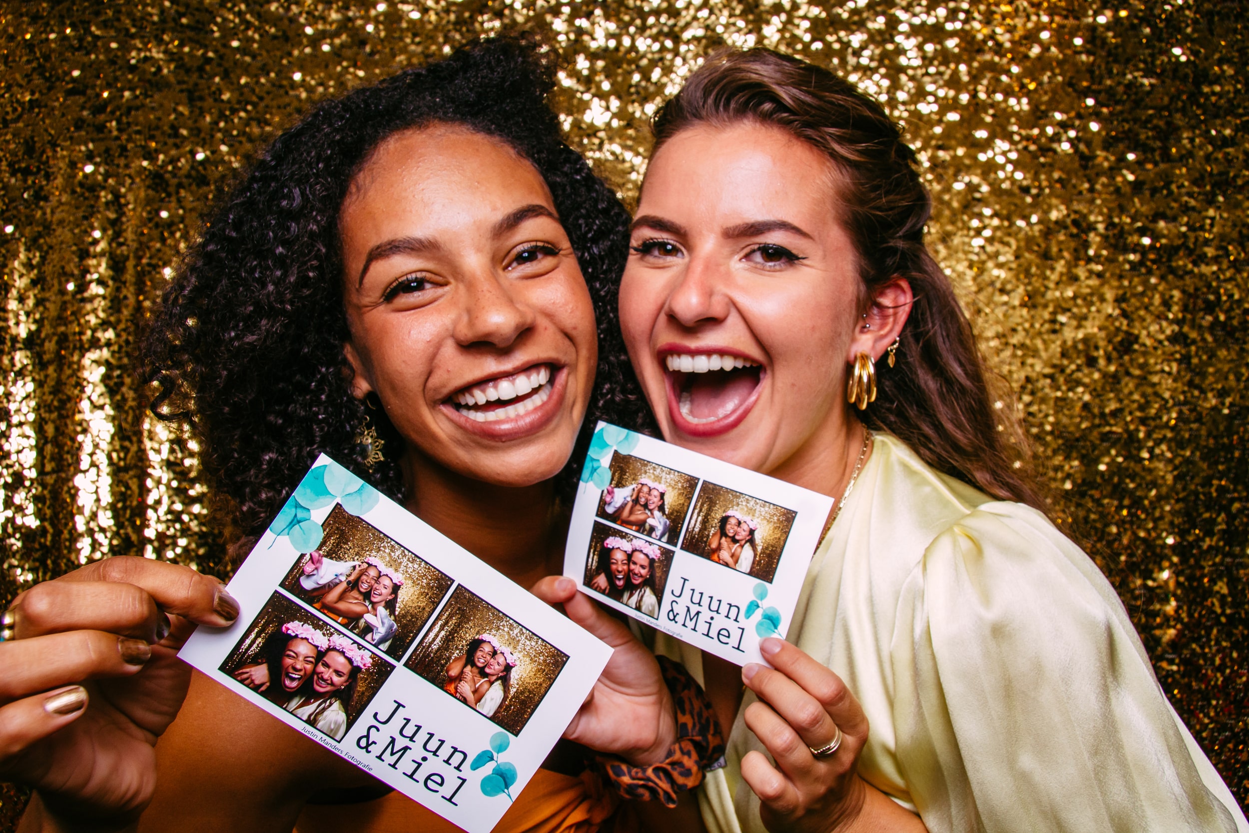 Guests holding custom photo booth prints at event