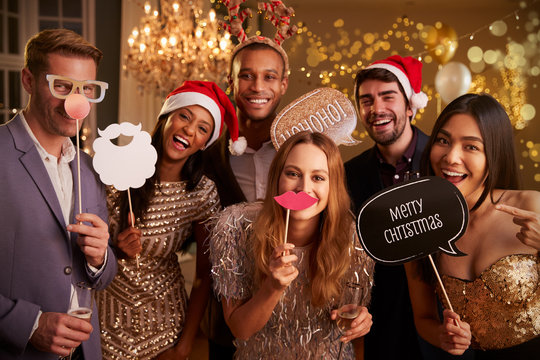 Holiday party guests using fun photo booth props