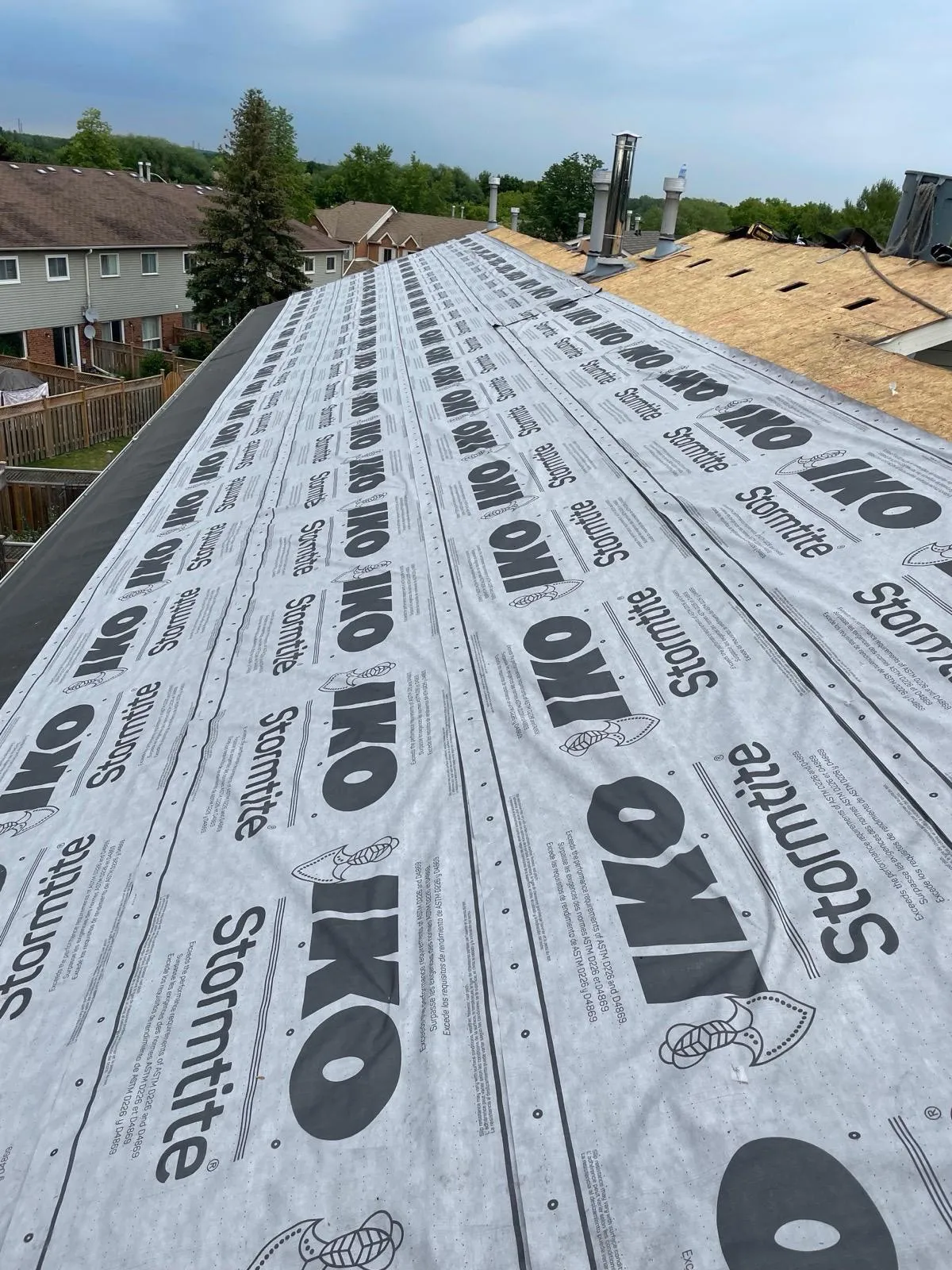 Residential roofing project with synthetic roof underlayment installation in preparation for a new metal roofing system by Infinity Gutters in Ontario