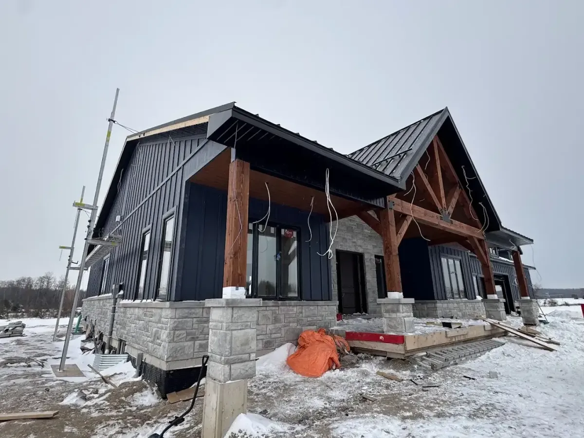 A custom Toronto home undergoing exterior renovations, featuring a newly installed dark metal roof and premium matching eavestroughs by Infinity Gutters.