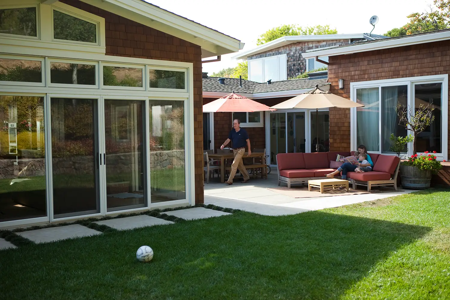 Image of seamless outdoor living design with covered patio, integrated kitchen, and durable decking in daylight.
