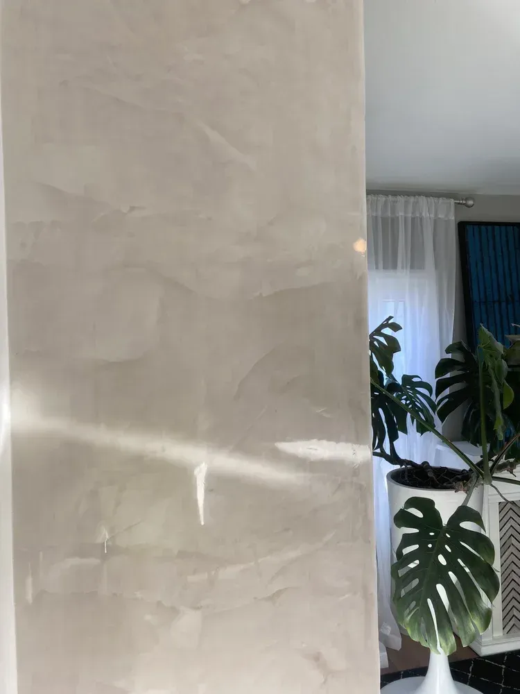 Hand-applied Venetian plaster architectural column with soft neutral movement and polished sheen