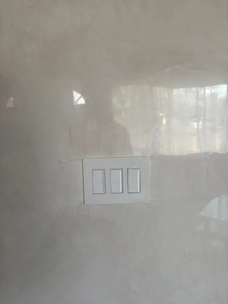 Close-up of polished Venetian plaster showing natural movement, depth and high-gloss reflection