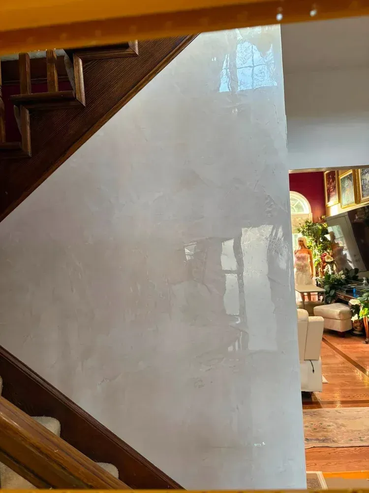 Polished Venetian plaster staircase wall with soft movement and luminous reflective finish