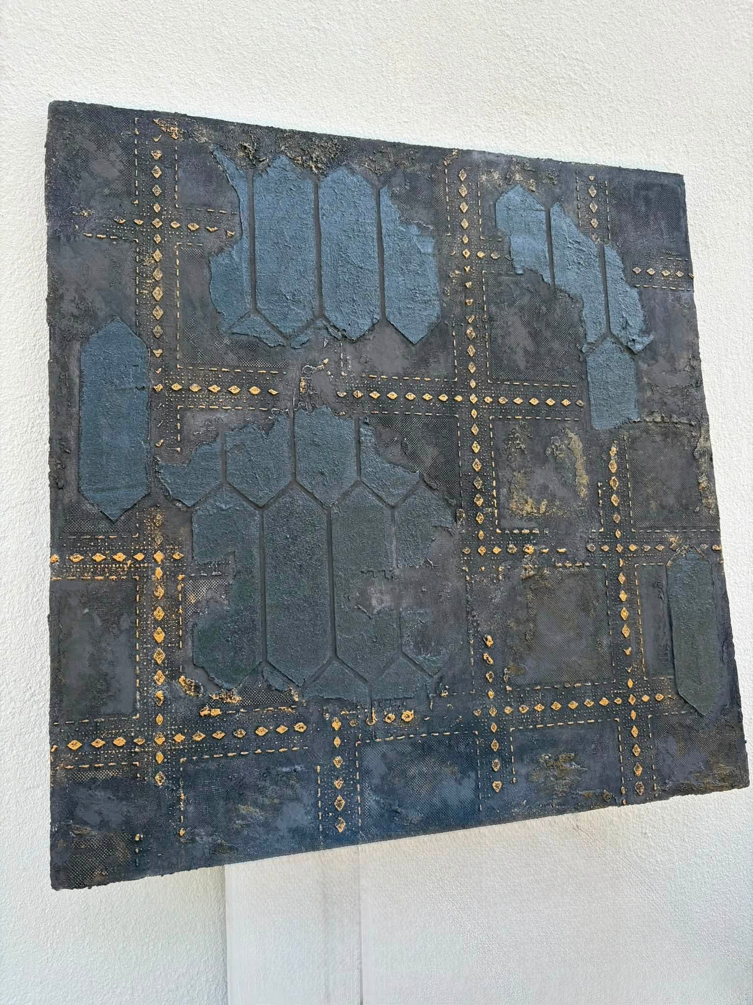 Custom blue decorative plaster sample with raised geometric texture and hand-applied gold detailing