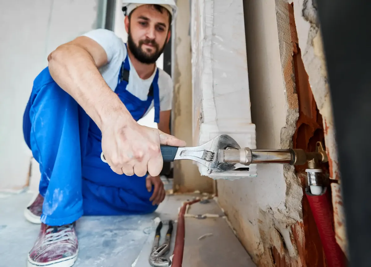 plumber near brandon Manitoba with wrench working on pipe