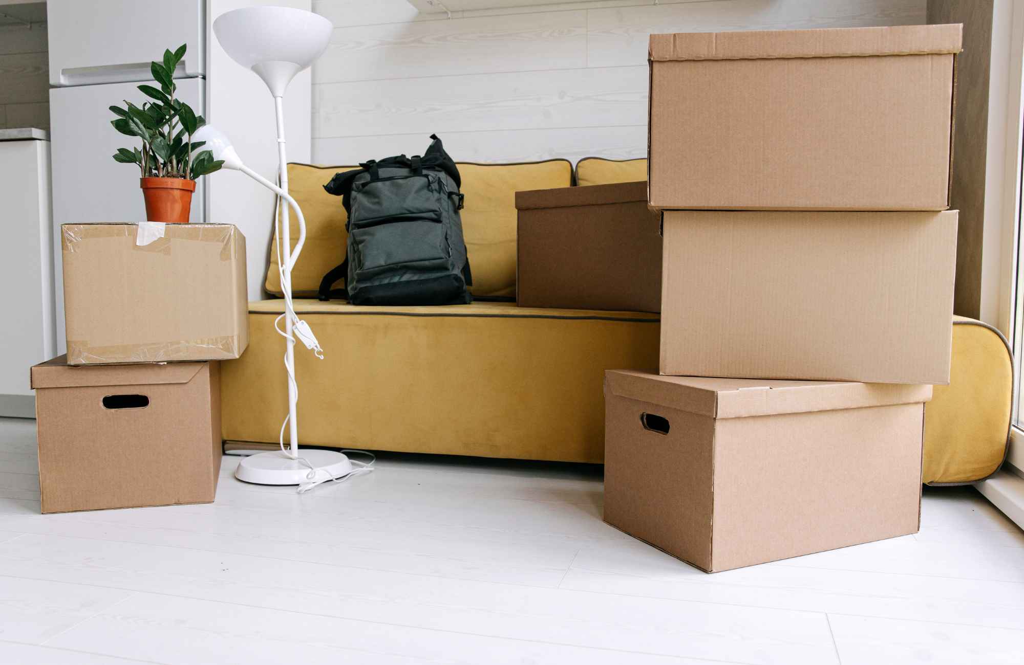 shannon's-organizing-solutions-lake-havasu-city-az-preparing-for-a-move-living-room-with-yellow-sofa-and-moving-boxes-stacked-efficient
