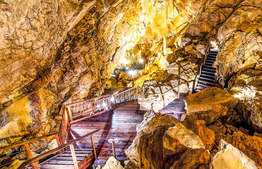 Vallorbe caves near Hôtel de la Truite with illuminated rock formations and stairs