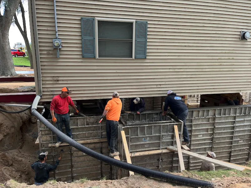 Concrete crew pouring a residential foundation wall