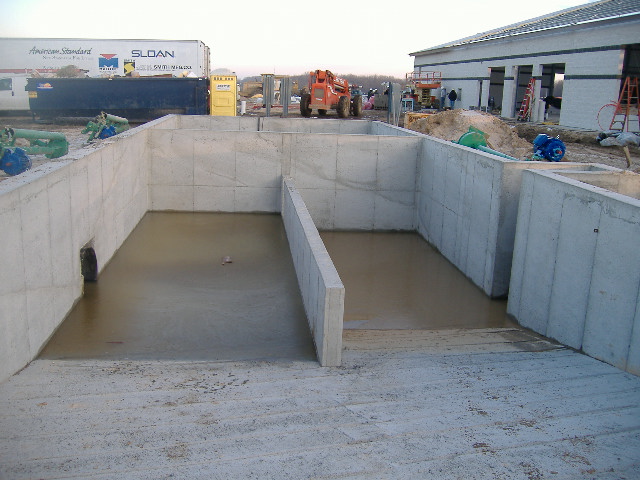 Concrete containment walls and divided bays at an agricultural facility