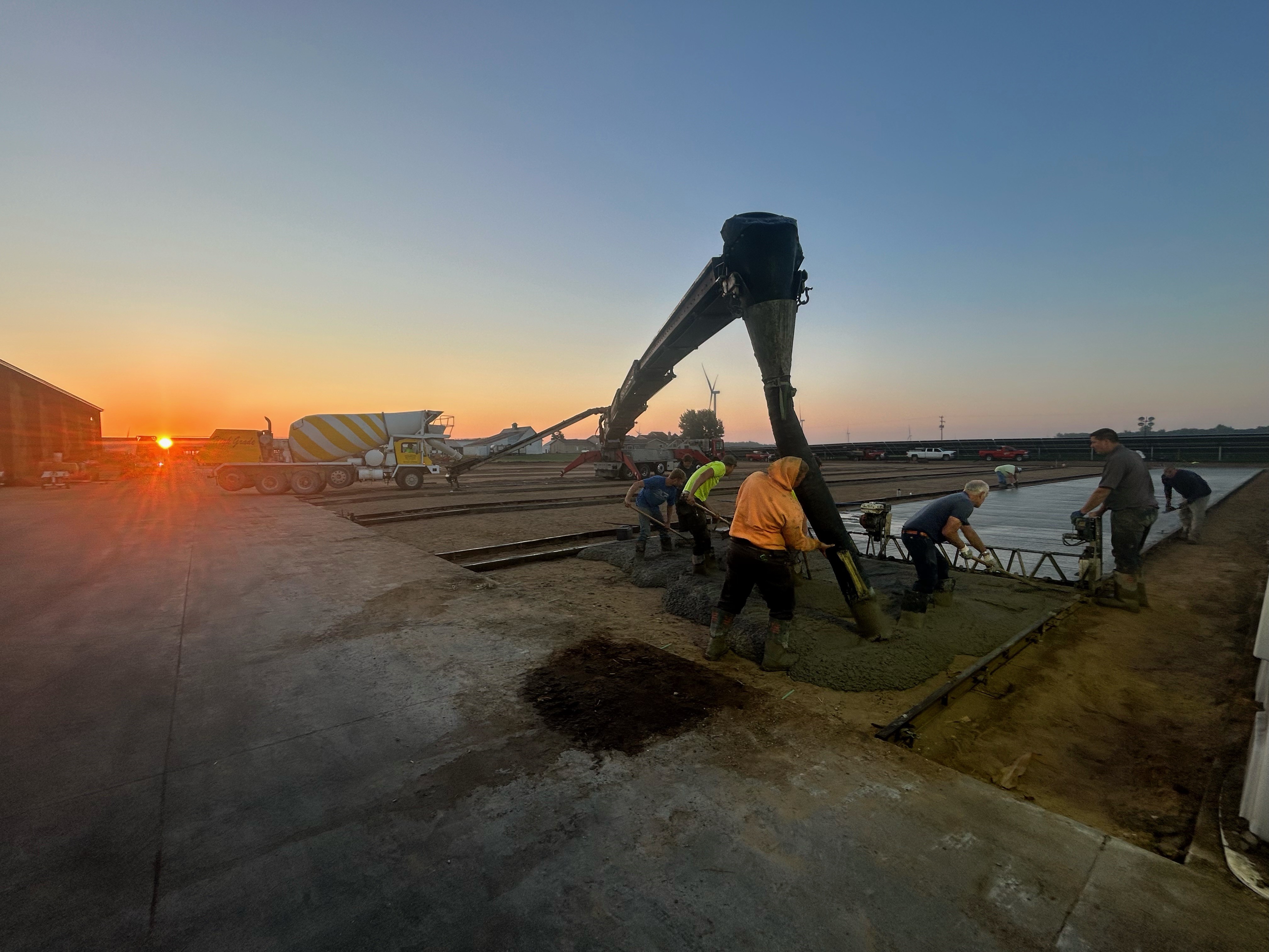Crew using telebelt to pour concrete outdoors