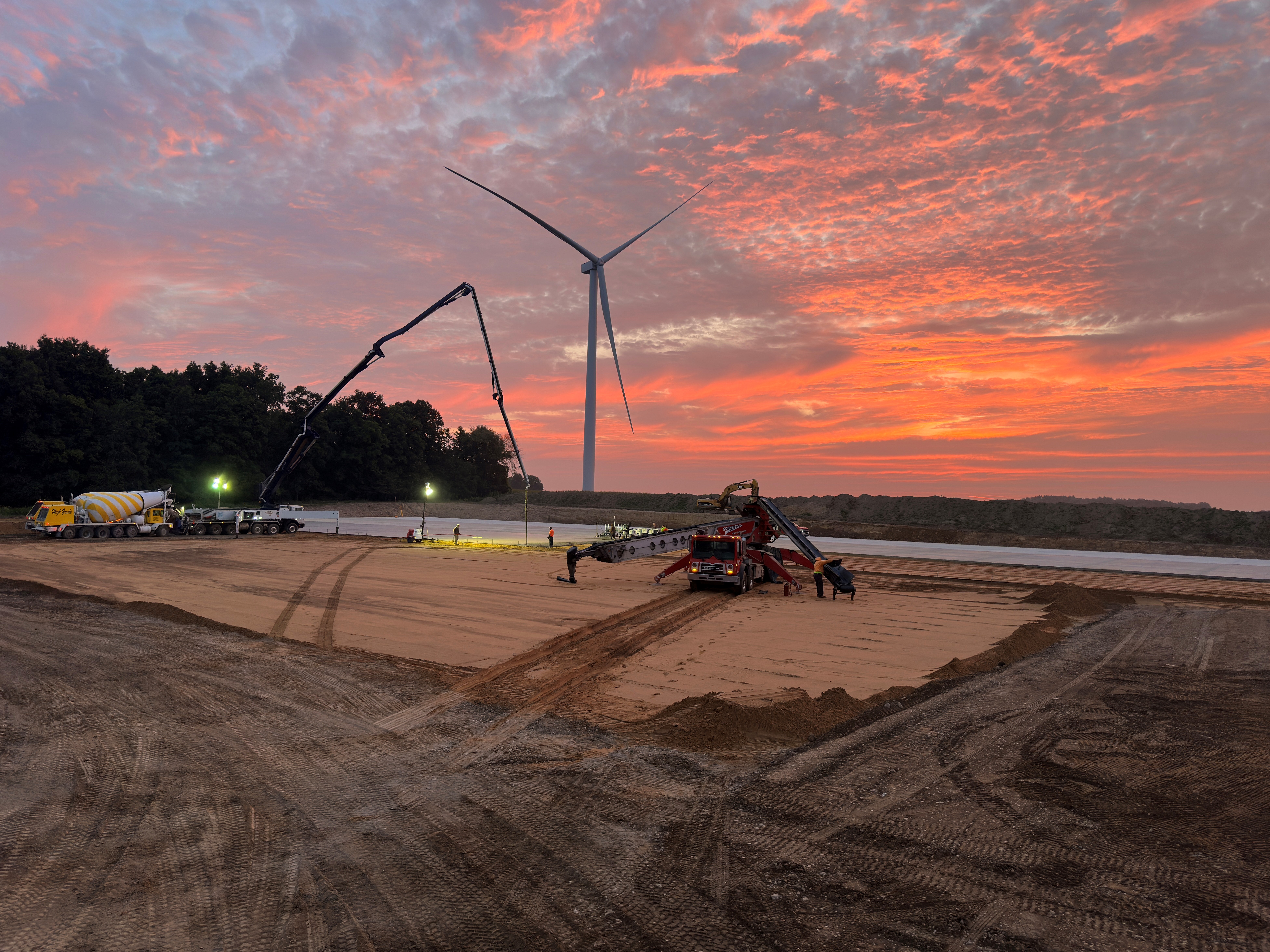 Sunset at a project location with large concrete pouring equipment