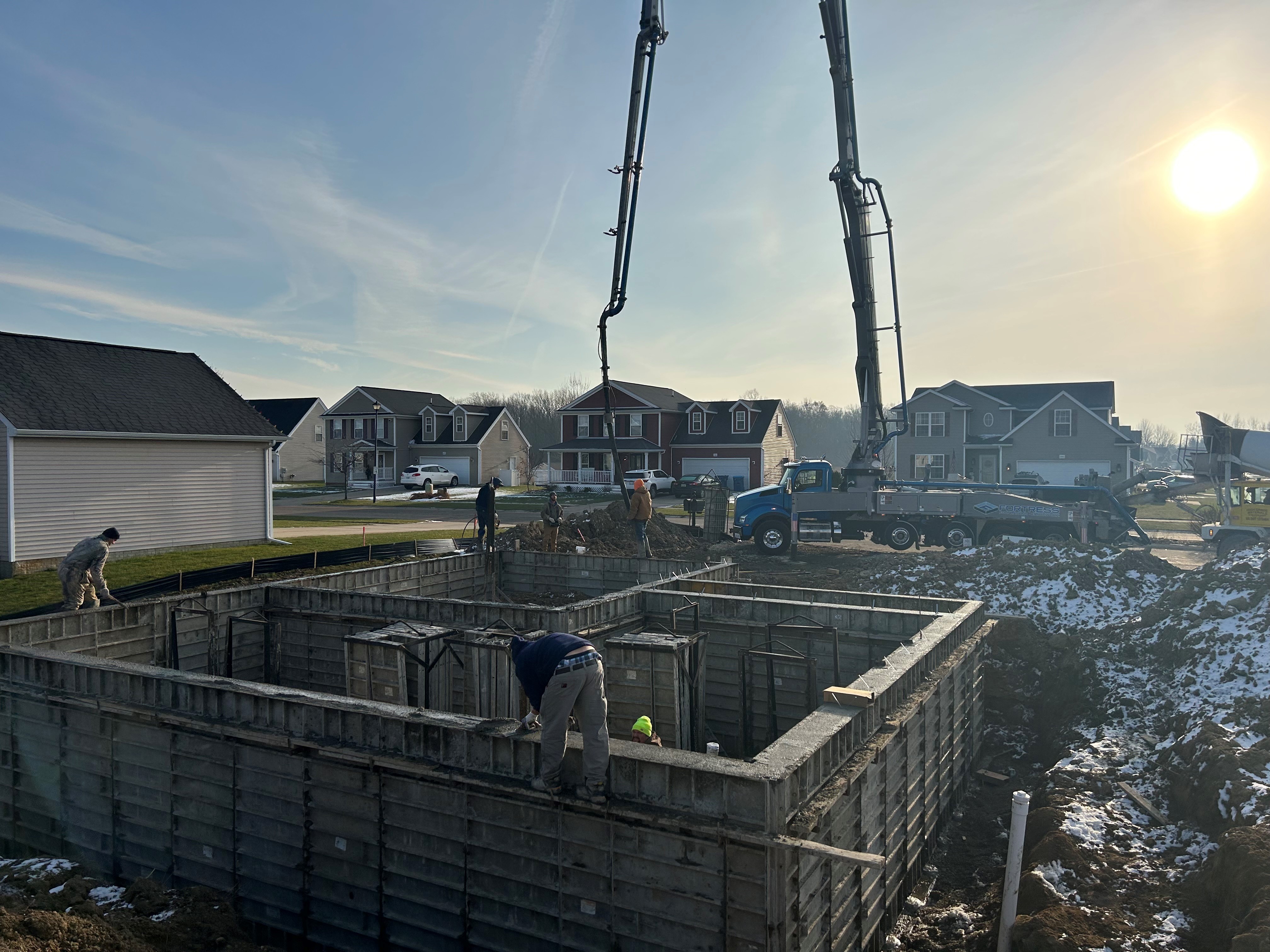 Work-in-progress residential foundation with concrete equipment