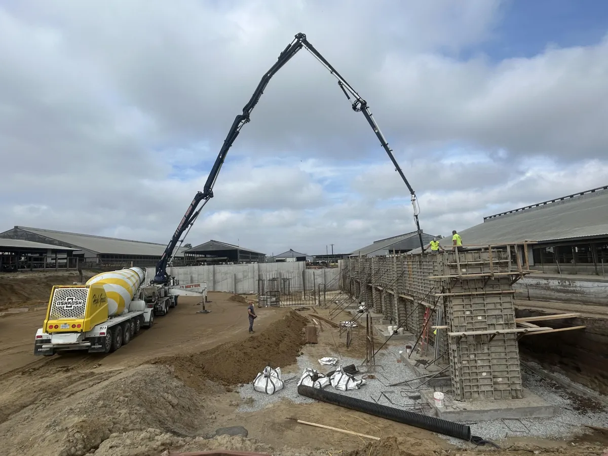 Concrete pouring equipment being used on hard-to-reach places at an agricultural site