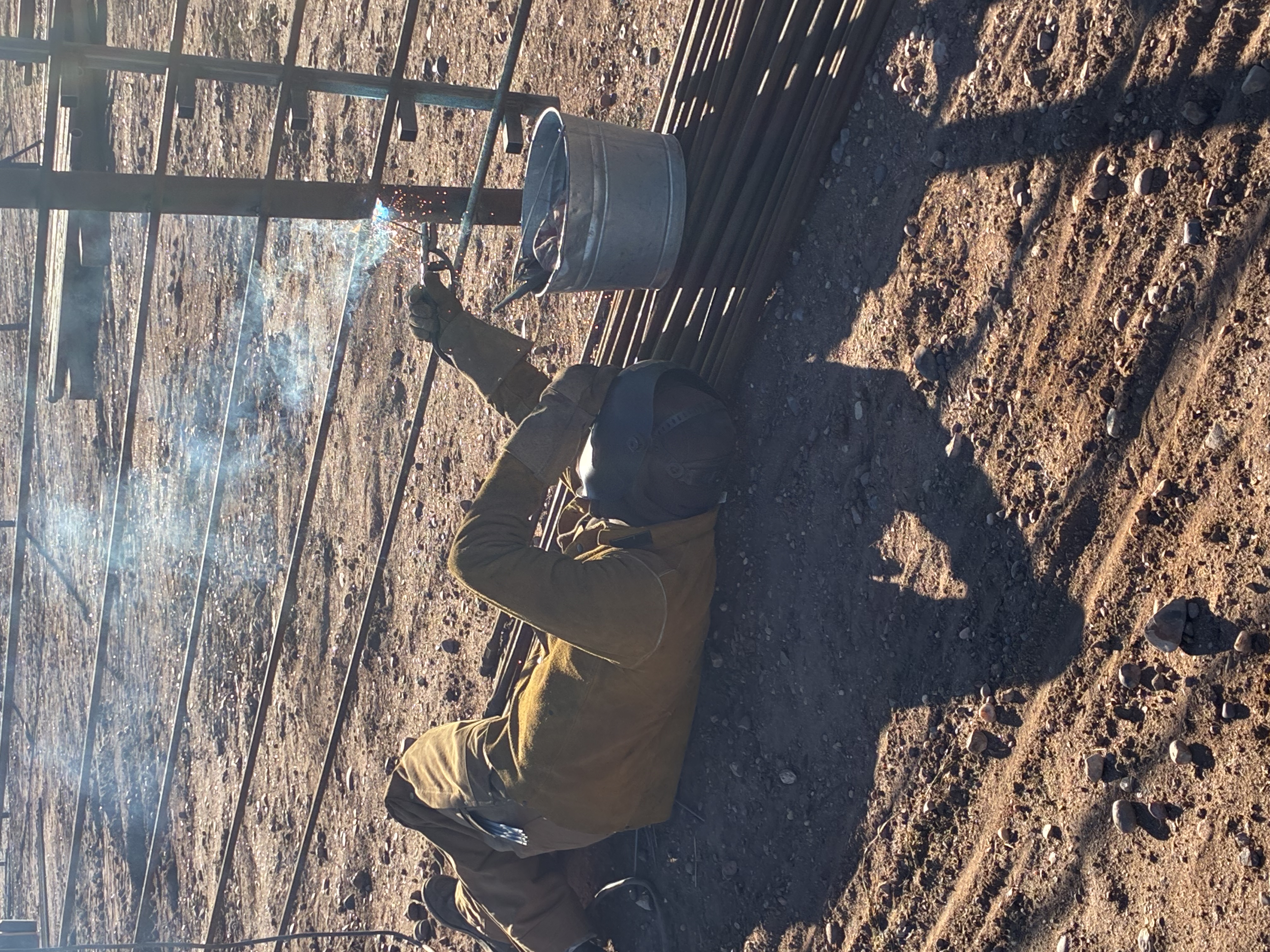 Newly installed wooden privacy fence with black metal gate hardware
