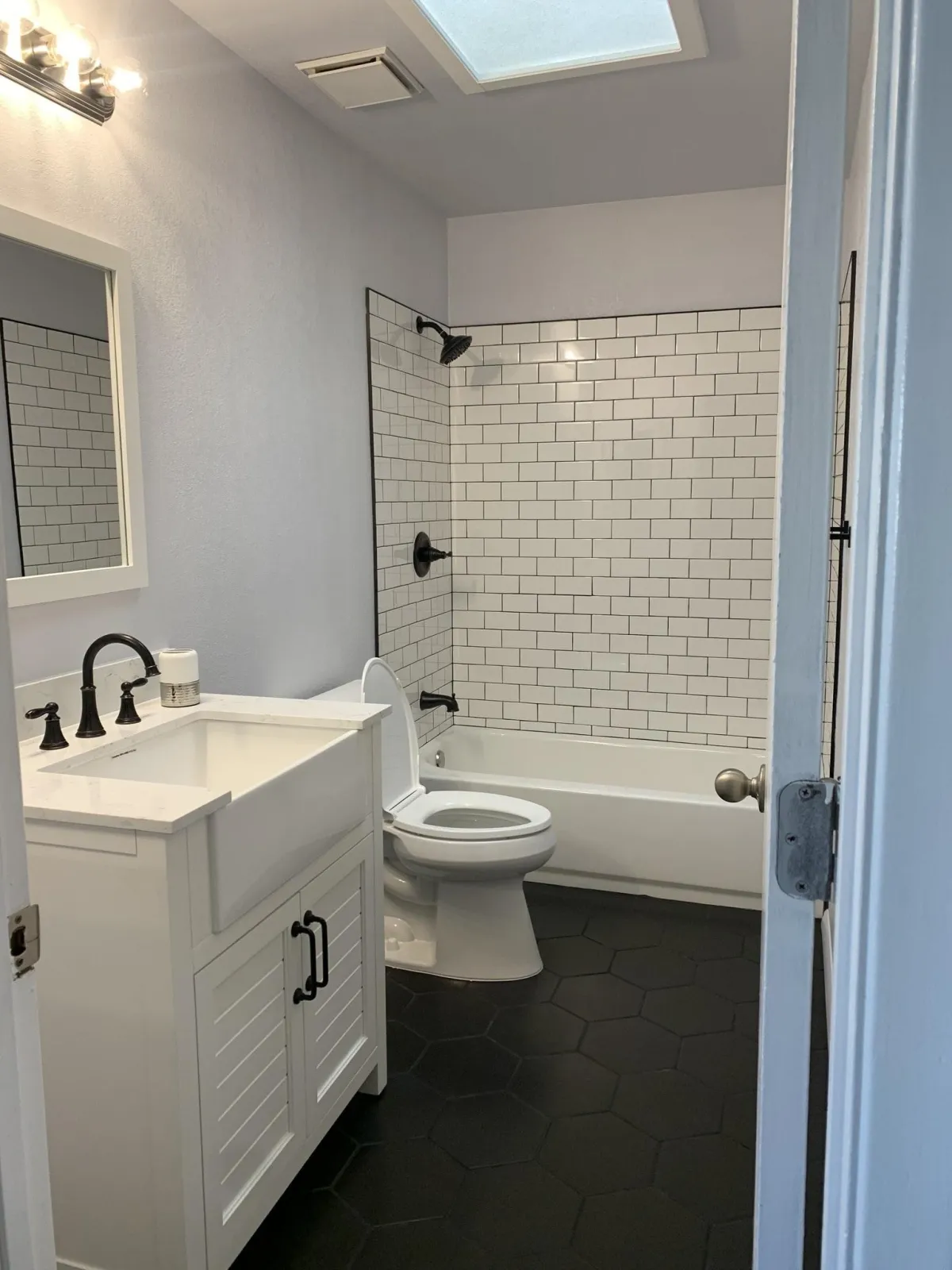 A modern bathroom with white subway tiles on walls