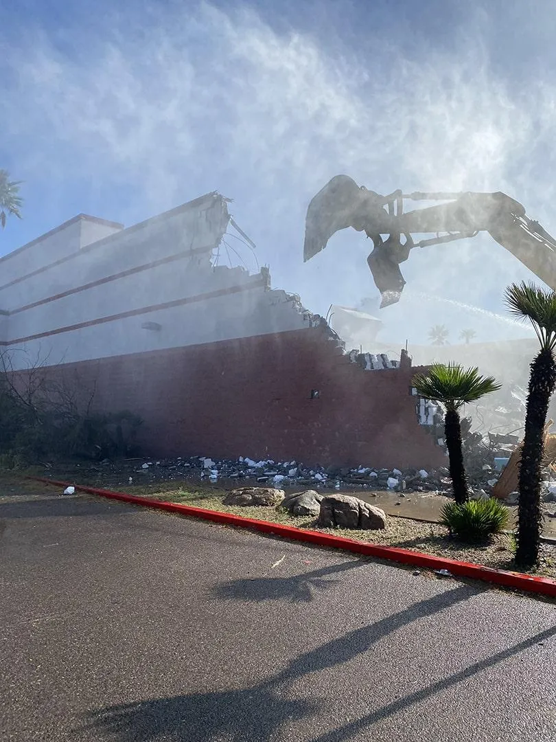 A construction excavator is demolishing a building