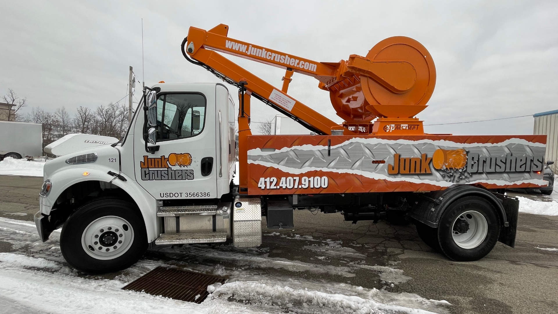 Commercial mobile trash compaction truck crushing open-top dumpster waste