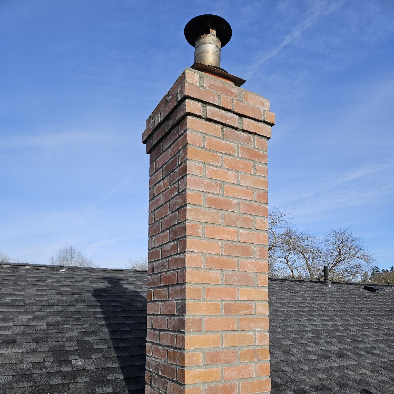 A circular image of a chimney on a roof top with a blue sky in the background that links to the Chimney page