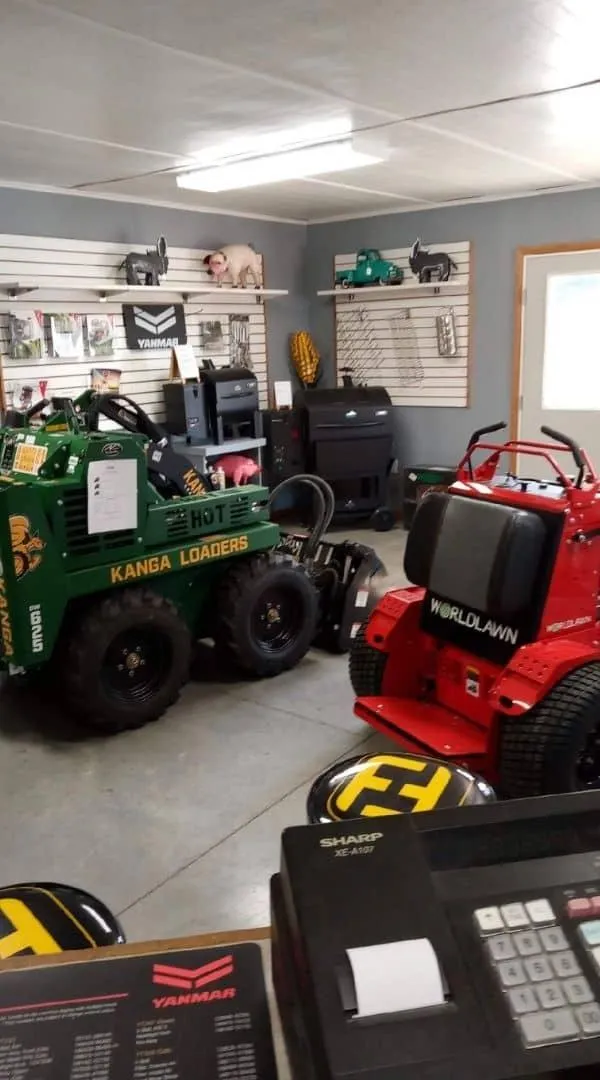 ZDE showroom displaying Kanga loaders and WorldLawn mowers with Yanmar brochures at Illinois dealership