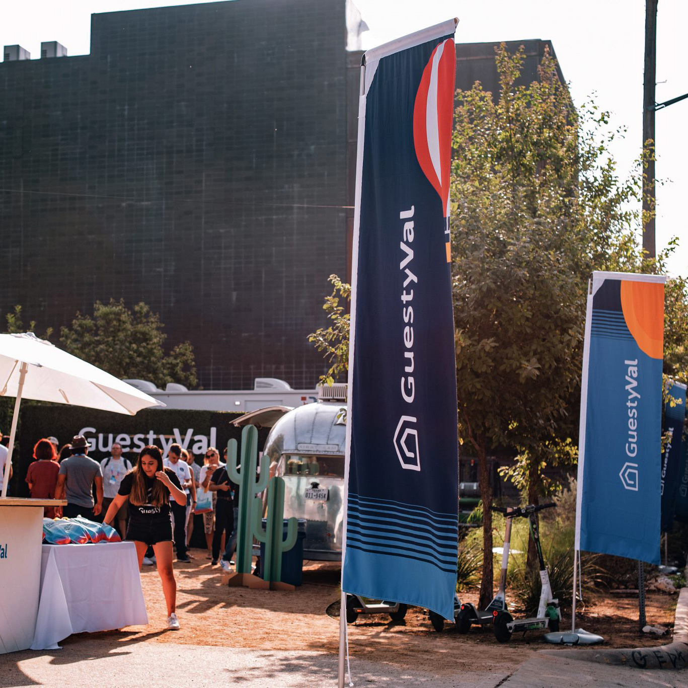 Bandera rectas - Landscape photo of straight mast flags arranged inside a shopping center near a kiosk, overhead lights and architectural context help show scale and suitability for indoor branding.