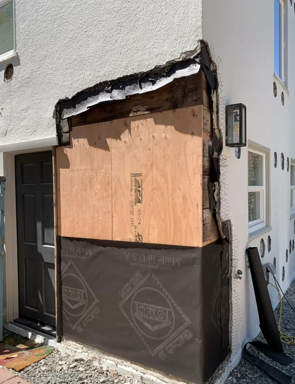 House with an exposed wall bing waterproofed for stucco