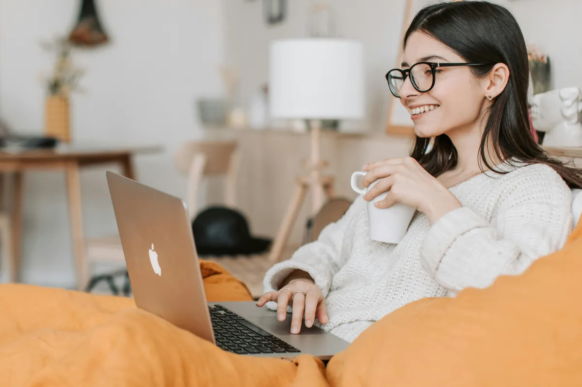 mother sitting with laptop in her lap communicating with therapist online