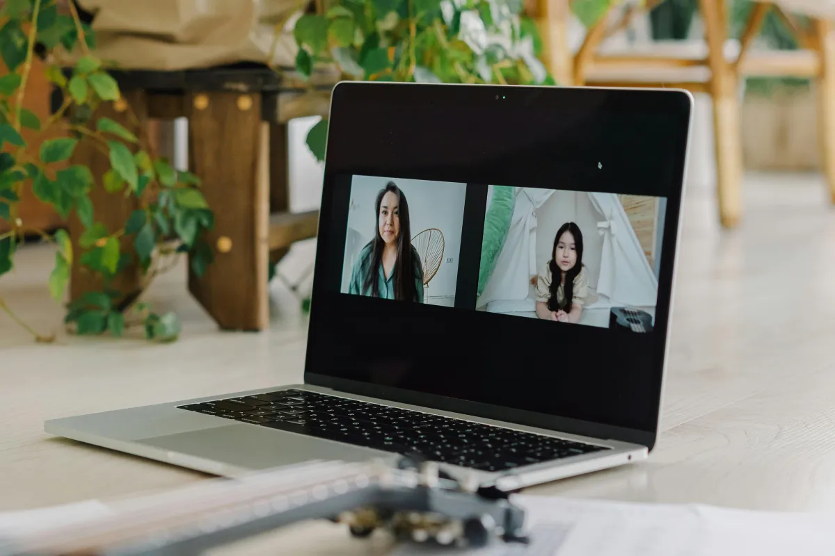 mother sitting with laptop in her lap communicating with therapist online